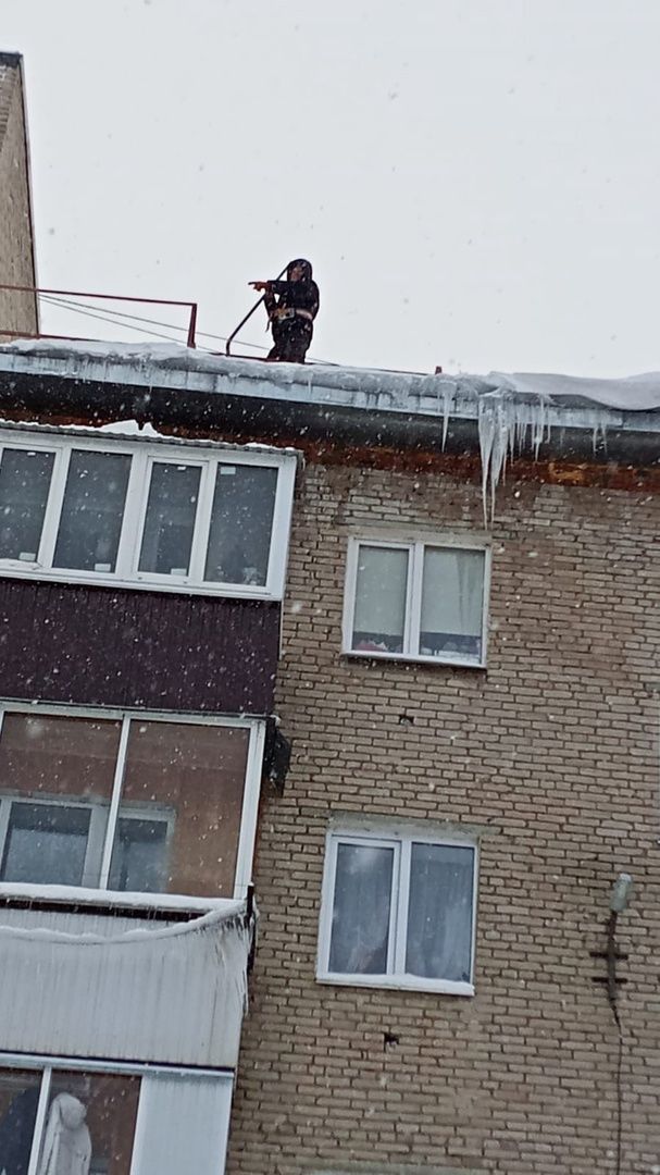 Сотрудники Управляющей компании убирают снег с крыш жилых домов